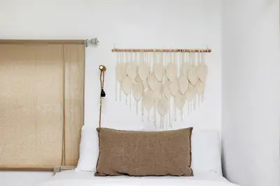 a bed with a pillow and a wall with feathers at Alton Rd By At Mine Hospitality in Miami Beach