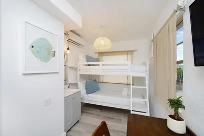 a small room with a bunk bed and a table at Alton Rd By At Mine Hospitality in Miami Beach