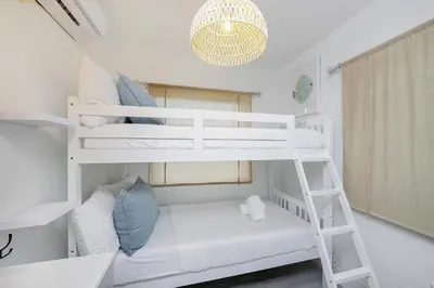 a bedroom with two bunk beds and a chandelier at Alton Rd By At Mine Hospitality in Miami Beach