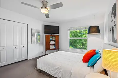a bedroom with a bed with a ceiling fan and a window at Waterfront Oasis with Pool, Sunset Views and Dock in Fort Lauderdale