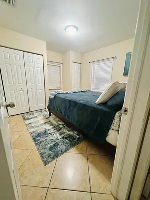 a bedroom with a bed and two white doors at Fort Lauderdale Florida Beach Vibe Hangout in Fort Lauderdale