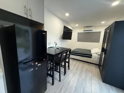 a small room with a table and a black refrigerator at Modern and private studio in Miami