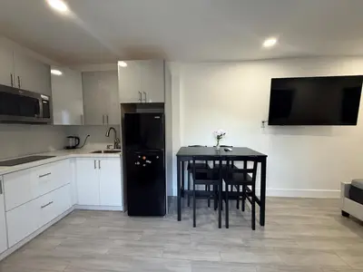 a kitchen with a table and a black refrigerator at Modern and private studio in Miami
