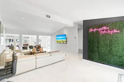 a living room with couches and a large green wall at Tropical 4 bed Pool Views in Fort Lauderdale