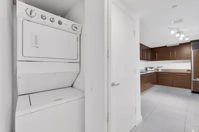 a kitchen with a white refrigerator and a white tile floor at Luxury Unit 1 Bed W Residences Brickell in Miami