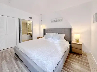 a bedroom with a large bed and a bathroom at Pool and Jacuzzi. Walk to beach, South Point Pier in Miami Beach