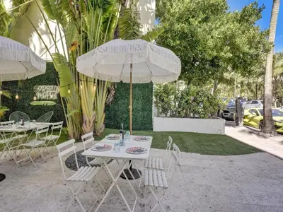 a table and chairs with umbrellas on a patio at Pool and Jacuzzi. Walk to beach, South Point Pier in Miami Beach