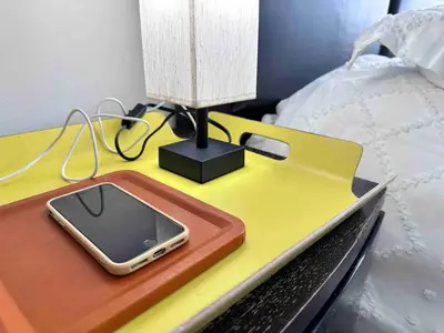 a table with a cell phone on it next to a bed at Right on the beach, Ocean Drive Secured Condo in Miami Beach