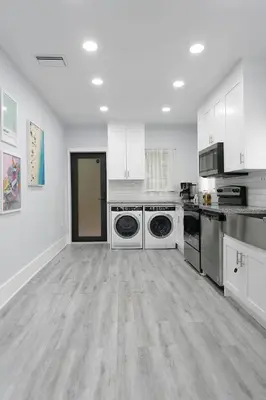 a large kitchen with white cabinets and appliances at Center Miami Designer Home 3 BR sleeps 9 in Miami