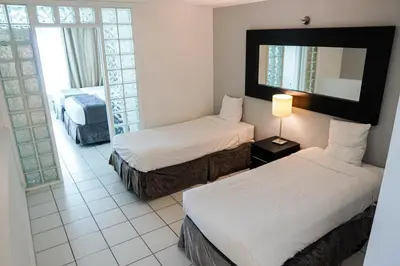 a hotel room with two beds and a mirror at Shine Suites Balcony Duplex 5 in Miami Beach