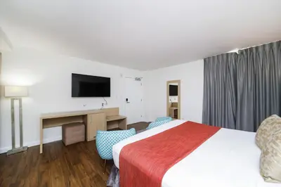 a hotel room with a bed and a desk and a tv at Villa Italia by At Mine Hospitality in Miami Beach