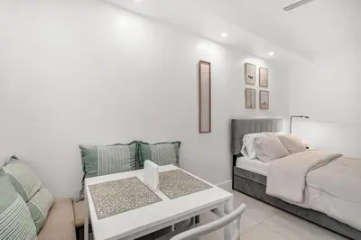 a white living room with a bed and a table at South of Fifth Oceanfront condo with Beach Perks! in Miami Beach