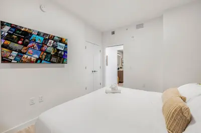 a white room with a bed and a painting on the wall at Luxury Escape At 72 Park in Miami Beach
