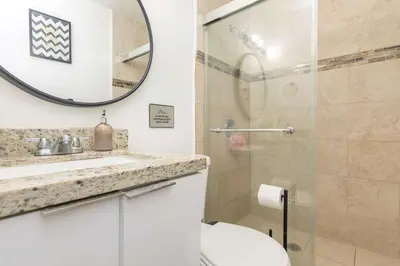 a bathroom with a toilet and a sink and a mirror at Charming 3BR Getaway - Central Miami Location in Miami