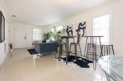 a living room with a table and some chairs at Charming 3BR Getaway - Central Miami Location in Miami