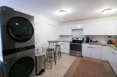 a kitchen with white cabinets and a large appliance at Charming 3BR Getaway - Central Miami Location in Miami