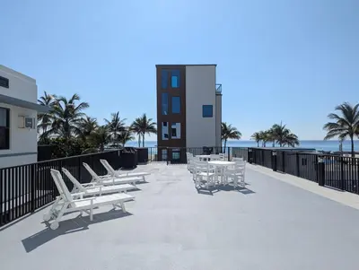 a row of chairs and tables on a balcony with the beach at Charming Beachside Studio - Steps to the Beach in Hollywood