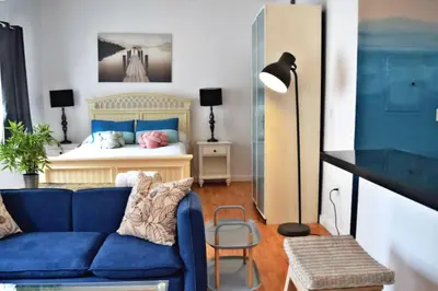 a living room with a blue couch and a bed at Light-Filled Apt Steps to Beach Convention Center in Miami Beach