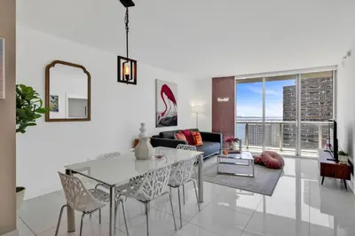 a living room with a table and chairs and a couch at W Hotel 2BR Ocean View, Pool, Spa, Free Gym Classes in Miami