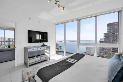 a living room with a tv and large windows at Wrap around Bay View, W Hotel Luxury 2BR 2BA, Pool, Spa, Free Gym Classes in Miami