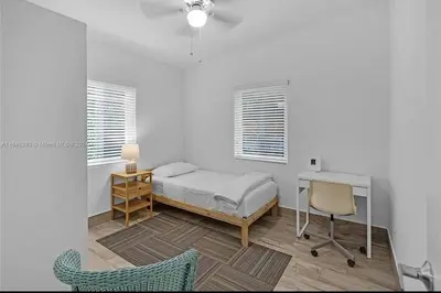 a bedroom with a bed and a desk and a chair at Avocado House in Miami