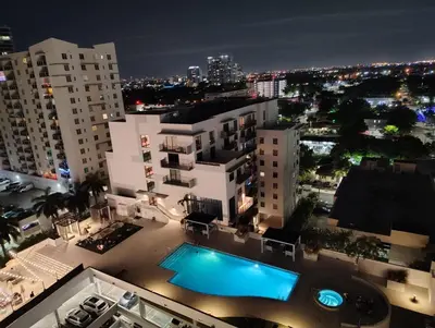 an overhead view of a swimming pool in a city at night at 2Bedroom 2 Bath condo 10 Mins Walking To Jackson Memorial Hospital in Miami