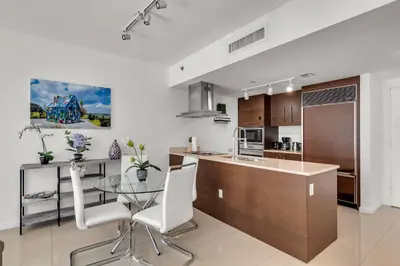 a kitchen with a glass table and white chairs at Icon Brickell Retreat 1BR and Spa, Pool, Views in Miami