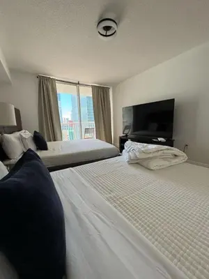 a hotel room with two beds and a flat screen tv at Elegant 1BR Condo at Brickell in Miami
