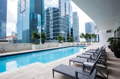 a pool with chairs and a view of the city at Cozy 2BR Apt at Brickell free parking in Miami