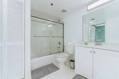 a white bathroom with a toilet and a shower at Lovely 2BR Rental in the Heart of Brickell in Miami