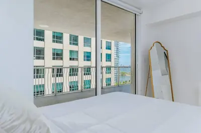 a bedroom with a bed and a large window at Amazing 2BR at Brickell Free Parking in Miami