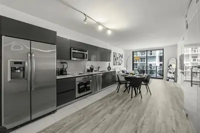 a kitchen with stainless steel appliances and a table with chairs at Luxurious 2Bedroom Apt Parking in Brickell. in Miami
