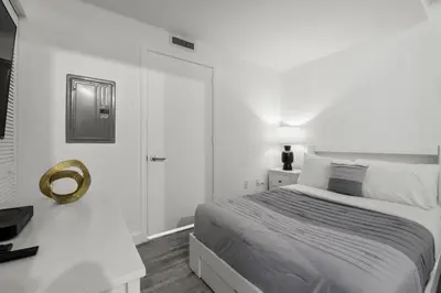 a white bedroom with a bed and a mirror at Luxurious 2Bedroom Apt Parking in Brickell. in Miami