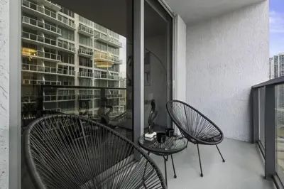 a balcony with two chairs and a table and a building at Luxurious 2Bedroom Apt Parking in Brickell. in Miami