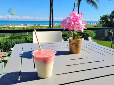a drink on a table with a view of the beach at Alexander14192 in Miami Beach