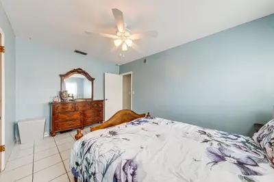 a bedroom with a bed with a ceiling fan and a dresser at 4 Mi to Hard Rock Stadium Miramar Home with BBQ! in Miramar