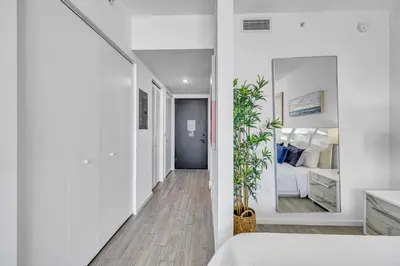 a white bedroom with a bed and a mirror at Sunset Waterview Oasis Studio in Miami