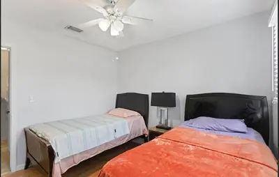 a bedroom with two beds and a ceiling fan at Spacious Home With King Bed Near Stadium in Norland