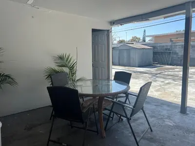 a glass table and chairs on a patio at Coral Gable 3BR House in Miami