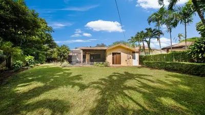 a house with a green yard with a palm tree at Private Entrance King Room and Private Bath UMiami in Miami