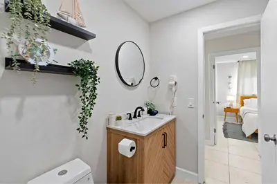 a bathroom with a sink and a toilet and a mirror at 6BR 3BA Heated Pool Miami Vacation in Miami
