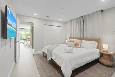 a bedroom with a bed and a flat screen tv at 6BR 3BA Heated Pool Miami Vacation in Miami