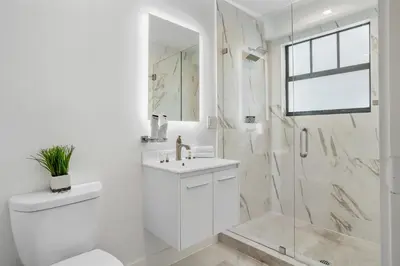 a white bathroom with a sink and a shower at The Firefly in Miami Beach