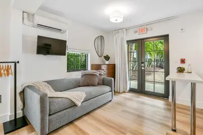 a living room with a couch and a tv at The Firefly in Miami Beach