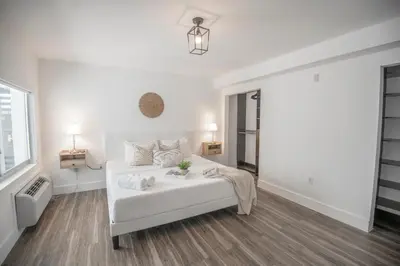 a white bedroom with a white bed and a window at Agave on the Beach in Miami Beach