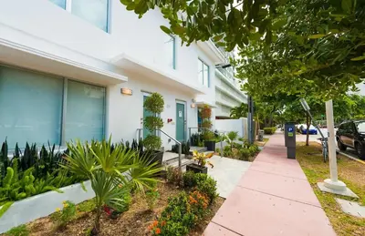 a sidewalk in front of a building with plants at Agave on the Beach in Miami Beach