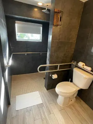 a bathroom with a toilet and a window at Agave on the Beach in Miami Beach