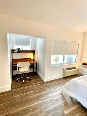 a bedroom with a desk and a bed and a chair at Agave on the Beach in Miami Beach