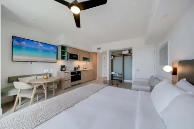 a bedroom with a large white bed and a table at Bellini Breeze - Cozy Central Miami Pool and Gym in Miami