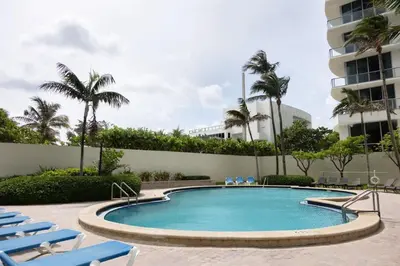 a swimming pool with lounge chairs and a building at Beachfront 2 BR Apartment full Kitchen- Sian in Hollywood
